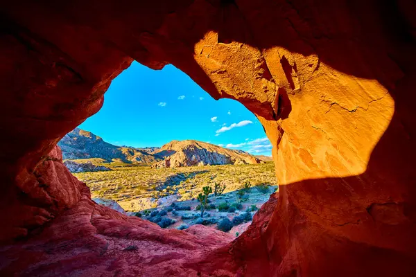 Kırmızı kumtaşı kemeri oluşumu, Nevada Ulusal Anıtı 'nda geniş bir çöl manzarası oluşturur. Altın saat gün batımı ışığı engebeli araziyi ve canlı gökyüzünü güçlendirir.