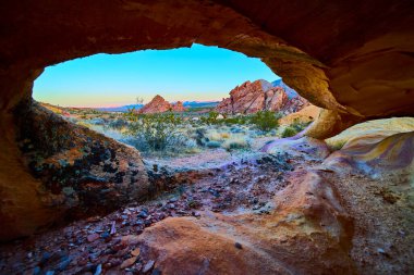 Renkli neapolitan kemer çerçeveleri engebeli çöl arazisi ve kayalık oluşumlar Altın Butte Ulusal Anıtı Nevada 'da gün doğumunda vahşi otlar ve açık gökyüzü ile