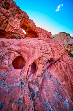 Nevada 'daki Whitney Pocket Ulusal Anıtı' nda parlak bir gökyüzü altında parlak kırmızı kumtaşı oluşumu ve engebeli dokular.