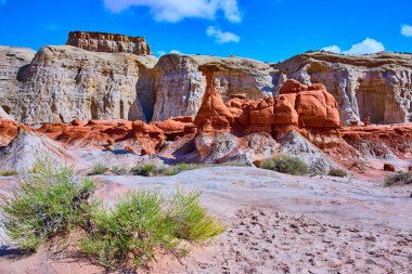 Kanab Utah yakınlarındaki engebeli çölden yükselen güneş taşı kabadayıları katmanlı kaya kayalıkları ve sert çalılarla Grand Staircase-Escalante National 'ın Toadstool Hoodoos' unda çarpıcı bir sahne hazırlıyorlar.