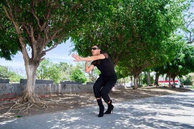 Genç LGBT dansçısı şehir sokaklarında vogue koreografisi yapıyor.