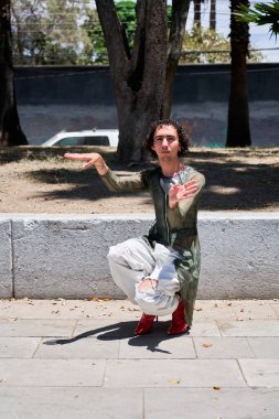 Genç LGBT dansçısı şehir sokaklarında vogue koreografisi yapıyor.