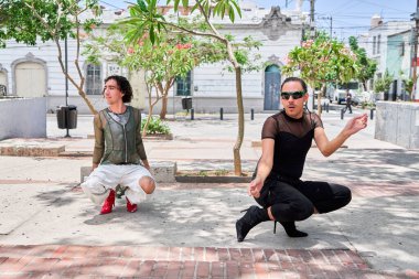 İki genç LGBT dansçısı şehir caddesinde vogue koreografisi yapıyor.                       