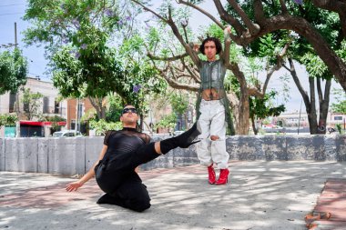 İki genç LGBT dansçısı şehir caddesinde vogue koreografisi yapıyor.                       