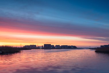 Hollanda, Meerstad 'da renkli bir gündoğumu sırasında limanda modern, özgür, ayakta duran evler..