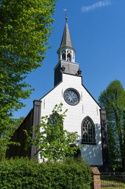 Eski kilise, Sint-Maartenskerk ve mezarlık Hollanda 'nın Groningen bölgesinde büyük ağaçlarla çevrili.