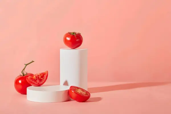 白いプラットフォームにピンクの背景に表示された新鮮なトマトのフロントビュー 新鮮な野菜で製品を表示するための空きスペース — ストック写真