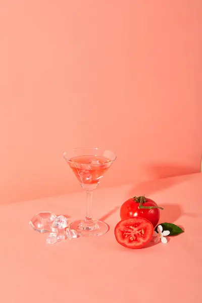 ピンクの背景にカクテルグラスが表示された新鮮なトマト トマトは 夜の失明を防ぎ 視力を高めるのに役立つビタミンAとCの素晴らしい源です — ストック写真