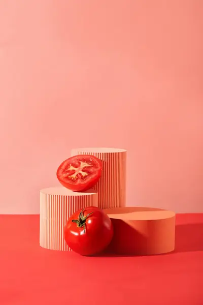 Fresh tomatoes and colored platforms are placed side by side on a pink background. Creative space for product display. Tomatoes are very good for people with cardiovascular disease and Alzheimer.