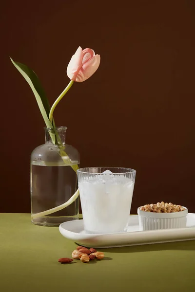 加满牛奶和冰块的杯子 放在有一碗大豆的盘子里 展示的杏仁和腰果很少 坚果对你的心脏非常有好处 — 图库照片