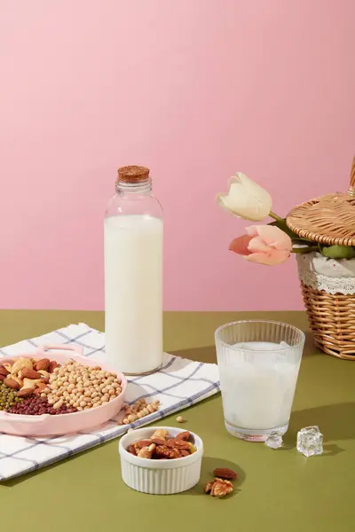 牛奶装在一个没有品牌的瓶子里 还有一杯冰块 展示了许多种类的有机坚果和豆子 坚果和豆子主要由脂肪组成 — 图库照片