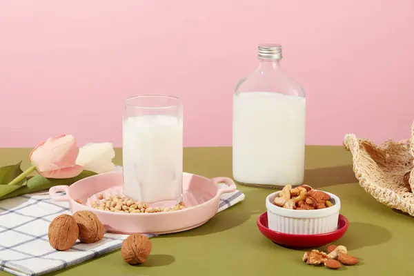 カップの中のナッツミルクとラベルなしのボトルで健康的な生活の概念 多くのナッツや豆が展示されています ナッツは健康に良い栄養豊富な食品です — ストック写真
