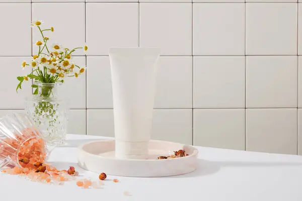 デイジーな花の鍋で飾られた白い色のブランクラベルチューブ 一部の人々は ピンクのヒマラヤ塩は通常のテーブル塩よりもナトリウムが低いと信じています — ストック写真