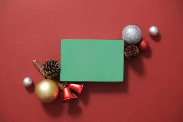 クリスマスのコンセプトのディスプレイ製品のための緑の空の表彰台を持つ赤い背景 バブル レッドベル ドライパインサラウンド表彰台 トップビュー — ストック写真