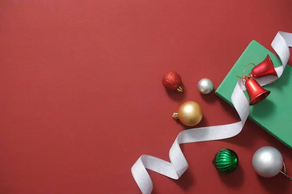 Vrolijk Kerstvakantie Concept Kerstversiering Kerstballen Klokken Linten Geschenkdoos Rode Achtergrond — Stockfoto