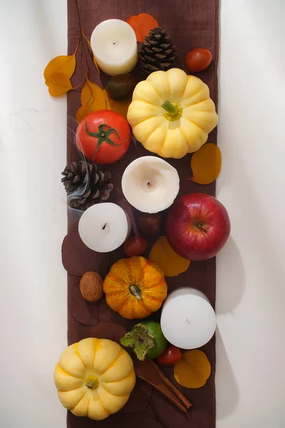 カボチャ 熟したトマト ドライパインコーン 白と茶色の背景にナットが付いているカラフルな秋の葉のフレーム 感謝祭コンセプトで広告するクリエイティブシーン — ストック写真