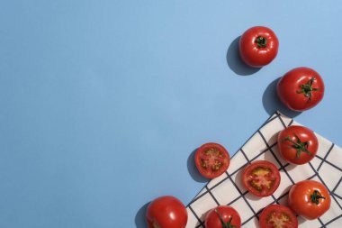 Mavi arka planda, kumaşla süslenmiş taze domates manzarası. Domates 'ten alınan ürün tanıtımı için boş alan (Solanum lycopersicum)