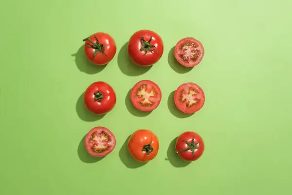 Top view of several tomatoes and halves of tomato are arranged in three lines. Rubbing tomato on face everyday will ensure the dead skin cells