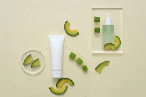 Natural avocado skin care products for healthy skin and hair with ingredient from avocado. Set of cosmetic bottles decorated with avocado slices on beige background. Top view, space for design