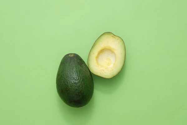 Top view of two slices of avocado isolated on green background. Advertising photo. Avocados are a fruit packed with carbohydrates and healthy fats that provide health benefits.