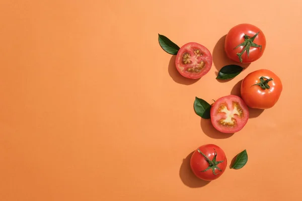 Fondo Naranja Con Algunas Hojas Verdes Tomates Cortados Por Mitad — Foto de Stock