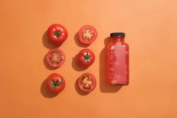 Tomatoes and slices of tomato arranged in two line with a bottle of tomato juice. Mockup design. The water content of tomatoes is around 95%