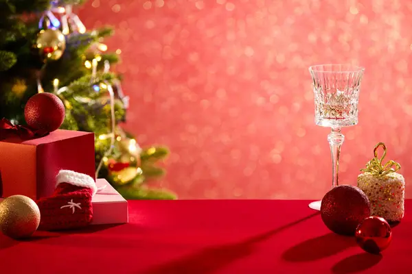 红色的表面有一些圣诞节的彩礼 酒杯和礼品盒 中间的空隙显示您的产品 佳节佳节社交后数码贺卡 — 图库照片