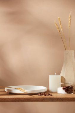 Kahve çekirdekli seramik tabak ve bej arka planda bir vazo dolusu buğday. Kozmetik, ticari markalaşma ve ürün sunumu için boş alanı olan minimal sanat arkaplanı