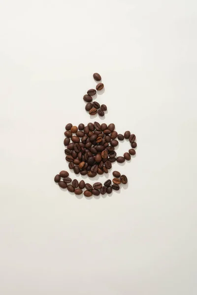 Białym Tle Brązowe Palone Ziarna Kawy Ułożone Kształcie Filiżanki Kawy — Zdjęcie stockowe