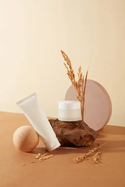 A jar of lotion and a tube of facial cleanser are displayed on a minimalist background. Blank labels for lettering design and cosmetic branding. Concept of cosmetics made from rice bran.
