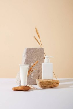 Etiketsiz bir kozmetik seti, içinde pirinç taneleri olan bir taş platforma yerleştirilir. Doğal ürün reklamcılığı için mükemmel bir arka plan. Vegan kozmetik kavramı.