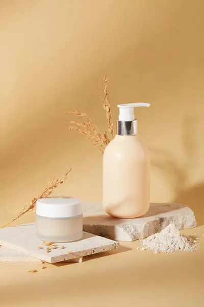 Front view of a jar of lotion and a bottle of shower gel are placed on a podium with rice bran powder on a beige background. Skin care with natural ingredients.