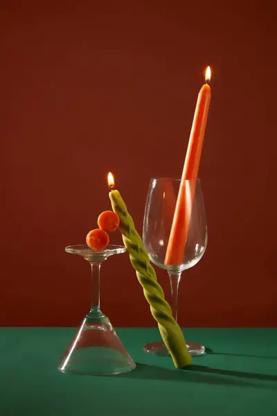 两支燃烧的蜡烛放在一个鸡尾酒杯和一个酒杯旁边 后面是深绿色和棕色的背景 广告和其他用途的神秘空间 — 图库照片
