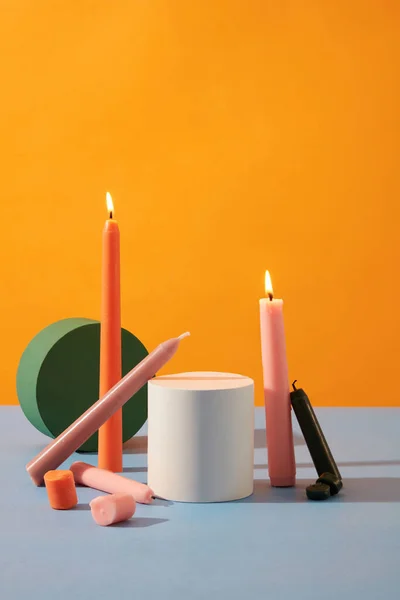 彩色蜡烛和圆形木制平台的前视图显示在黄紫色背景上 产品展示和广告空间 — 图库照片