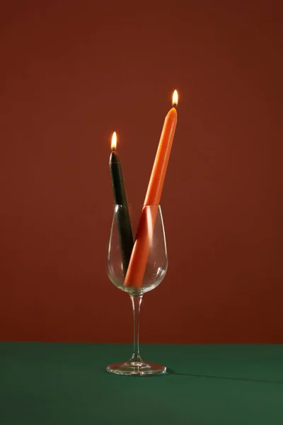 Twee Brandende Kaarsen Worden Transparante Wijnglazen Geplaatst Een Diep Groen — Stockfoto