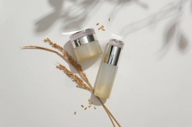 Beyaz arka planda pirinç ile etiketlenmemiş bir kozmetik seti. Doğal malzemelerle kaliteli kozmetik ürünlerinin reklamını yapmak için mükemmel bir yer..