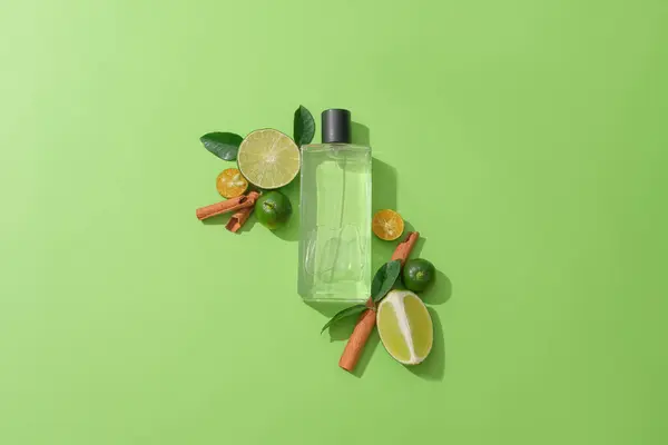 透明な香水ボトルは 緑色の背景にクムカート レモン シナモンが表示されます 広告のための化粧品モックアップ ハーブの香り — ストック写真