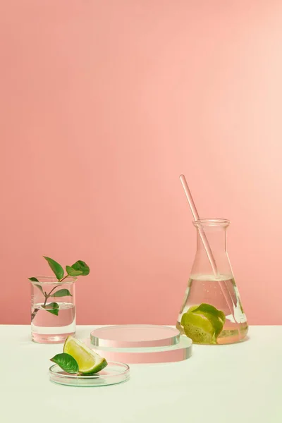유리와 신선한 레몬은 핑크색 배경이 테이블에 놓입니다 공간은 화장품 광고에 — 스톡 사진