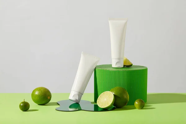 Dwie Tuby Kosmetyków Wyświetlane Zieloną Platformą Świeżą Cytryną Akrylową Blachą — Zdjęcie stockowe