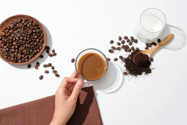 Hand Holding Cup Coffee Coffee Beans Wooden Plate Glass Milk — Stock Photo, Image