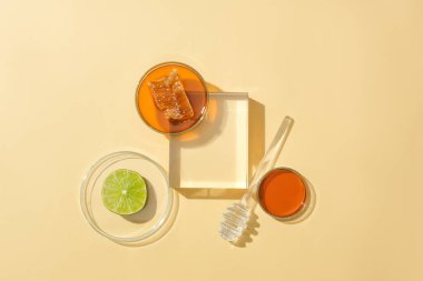 Cam eşyalar, bal ve taze limon pastel arka planda göze çarpıyor. Bal içeren araştırma ve geliştirme ürünleri. Bal, yaraları iyileştirir ve yaraları kapatır..