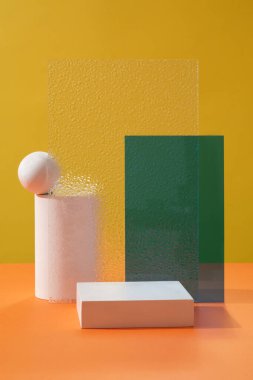 Ürün sunum sahnesi için minimum boş platform - podyum geometrik şekli, sarı zemin üzerine dekore edilmiş şeffaf ve yeşil akrilik çarşaflar. Ön görünüm