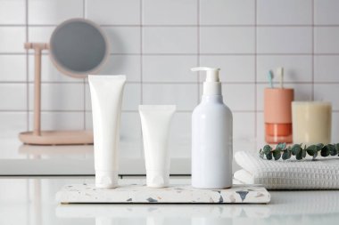 Boş şişe konteyneri kremi, temizleyici ya da mermer bir podyumda sergilenen mermer duvar arkası, tuvalet malzemeleri, ayna ve kokulu mumlar. Tasarım için maket. Kozmetik reklamları.