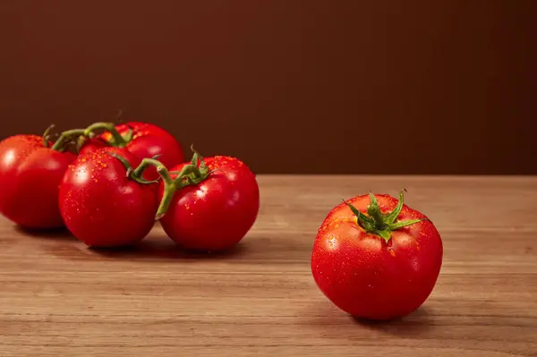 Close-up of a bunch of fresh cherry tomatoes with drop water on rustic wooden background, Space for cosmetic product mockup. Product and promotion concept for advertising