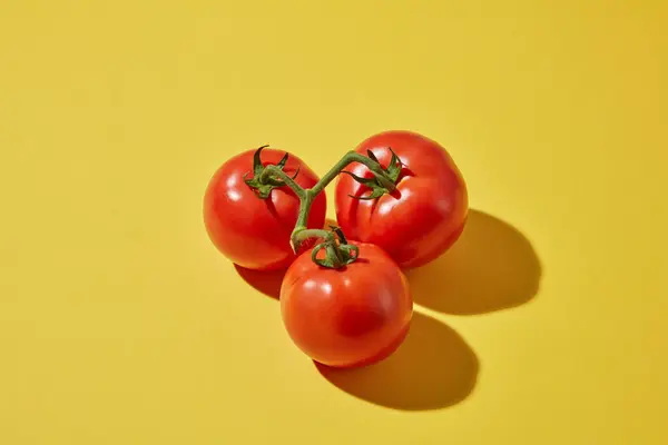 果物のミニマルシーン 黄色の背景に影のある3つの熟した新鮮なトマトのトップビュー トマトには健康と免疫システムに有益な多くの栄養素が含まれています — ストック写真