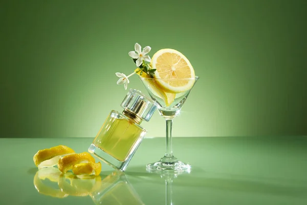 没有标签的香水瓶原型 柠檬片和果皮 绿色背景装饰的玻璃杯 柠檬精油中的香精油具有新鲜 愉悦的香味 — 图库照片