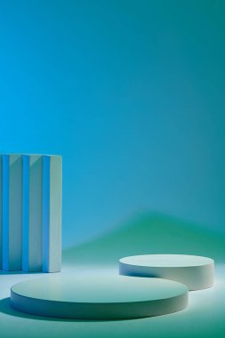 Gradyan mavi arkaplanda gösterilen boş yuvarlak podyumların ön görünümü. Tasarım için yer, yer modeli. Boş minimalist boş gösteri şablonu