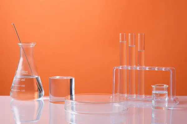 Vooraanzicht Van Laboratoriumapparatuur Erlenmeyer Reageerbuizen Bekergevuld Kleurloos Vloeistof Cilinderpodium Voor — Stockfoto