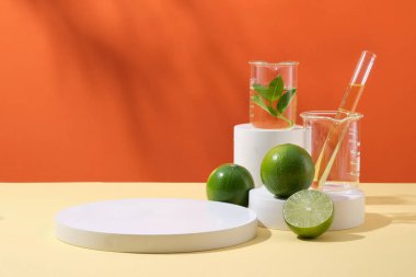 Turuncu zemin üzerinde sarı sıvı bulunan yuvarlak boş podyum, limon ve laboratuvar camlarıyla kozmetik ürün sunumu için kaldırım taşı. Reklam fotoğrafı, kopyalama alanı