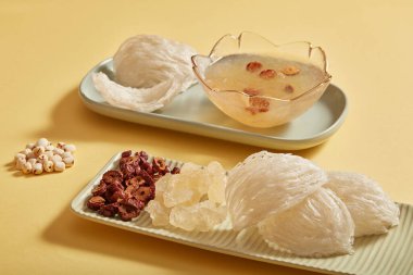 Kuş yuvası, jube, nilüfer tohumu ve bej arka planda kaya şekeri ile damıtma malzemelerini kapatın. Yiyecek ve bitkiler sağlık için, yaşlanma karşıtı, bağışıklık sistemini güçlendirir..